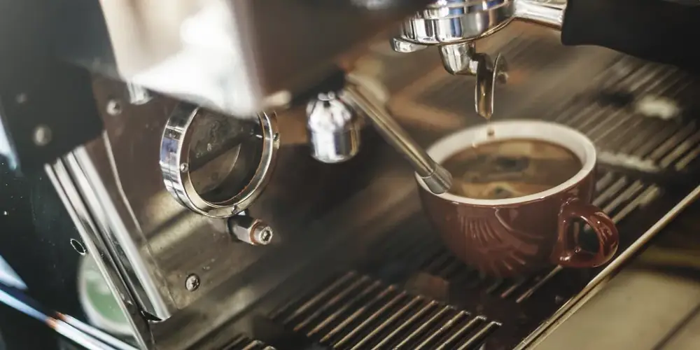 An espresso machine pouring a shot into a small cup